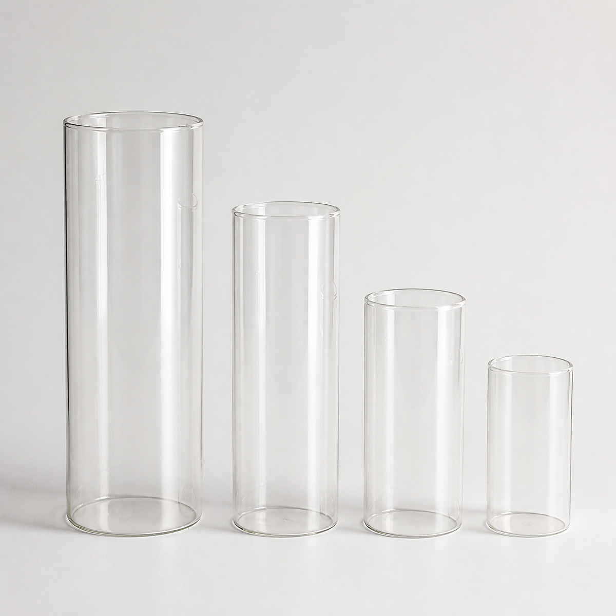 Set of four clear glass cylinder vases in graduated heights