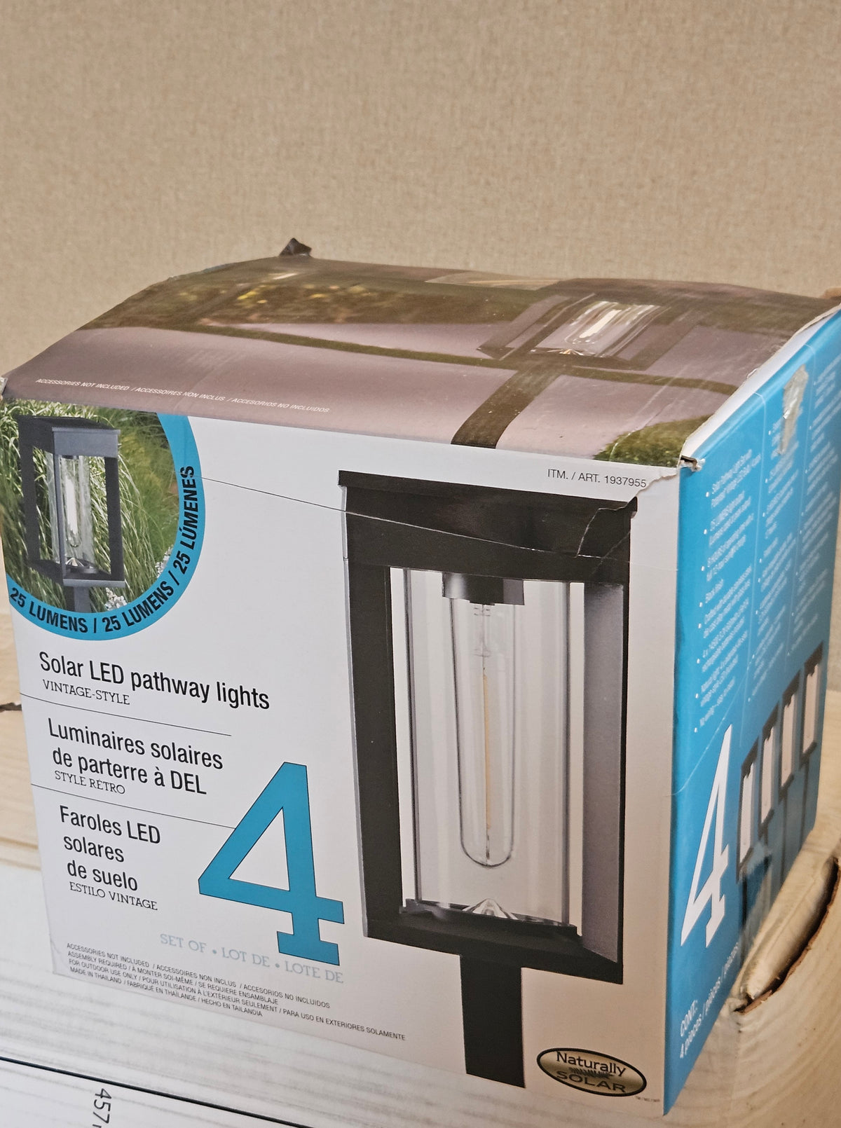 A 4-pack of vintage-style solar LED pathway lights in their original retail packaging, showing the front and side panels of the box.